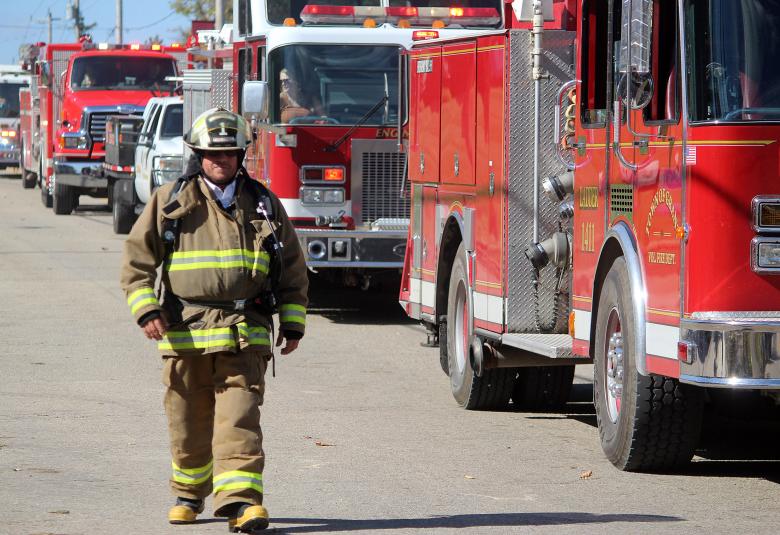 Town of Grant Fire Chief John Henselin walks the parade route in full gear Oct. 5 as he’s followed by fire engines from his own fire department, as well as Marion and the Town of Pella.