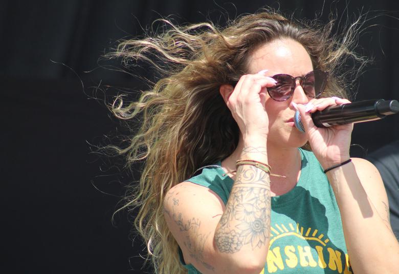 Jess Marie, female lead vocalist for the Spicy Tie Band, adjusts her sunglasses and sings during the band’s June 6 performance at Sun Drop Dayz.  (Kevin Passon | NEW Media)